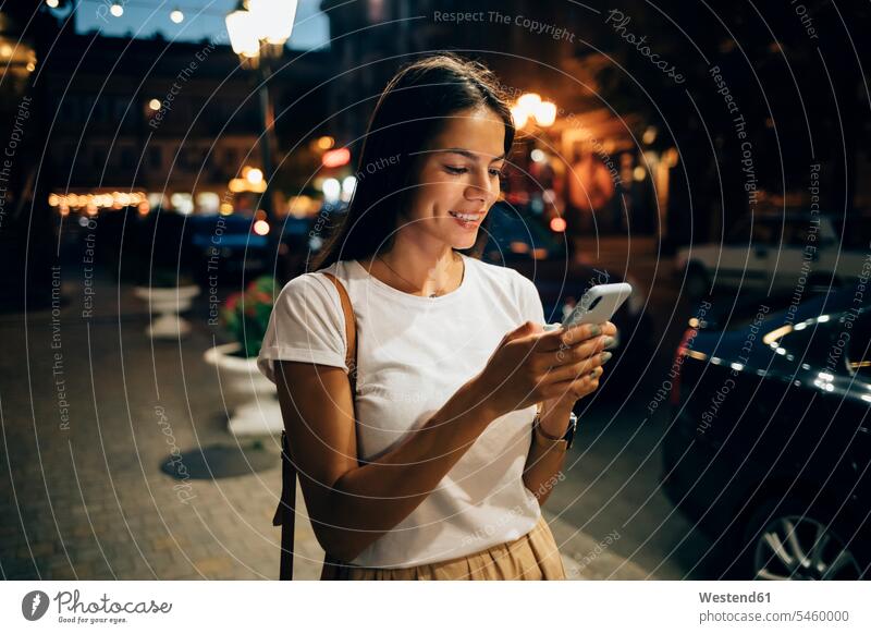 Young woman using smartphone in the city at night telecommunication phones telephone telephones cell phone cell phones Cellphone mobile mobile phones mobiles