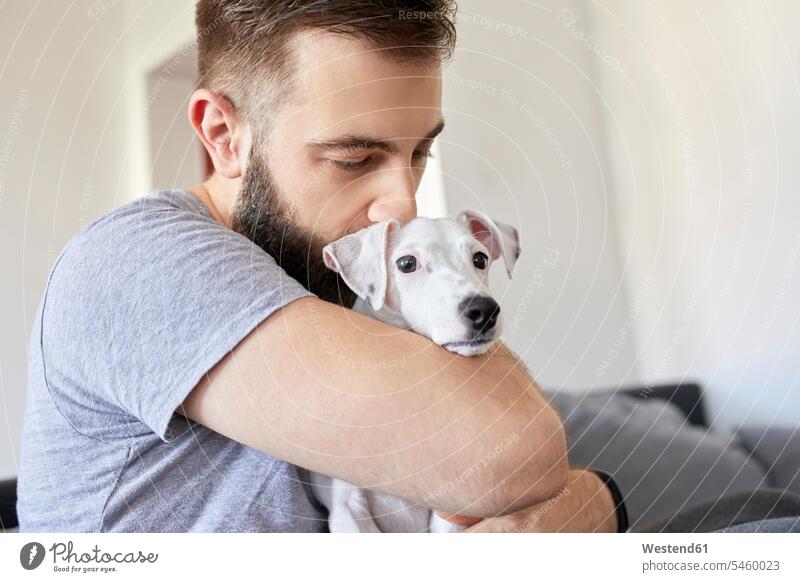 Man cuddling his dog at home dogs Canine hugging man men males pets animal creatures animals Adults grown-ups grownups adult people persons human being humans