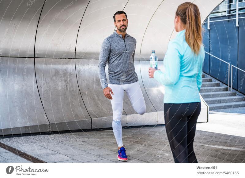 Active couple with water bottle in the city town cities towns exercise exercises active water bottles bottled water twosomes partnership couples outdoors