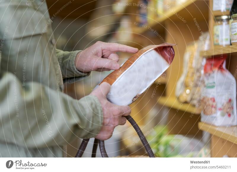 Close-up of senior man buying groceries in a small food store checking ingredients human human being human beings humans person persons client clientele clients