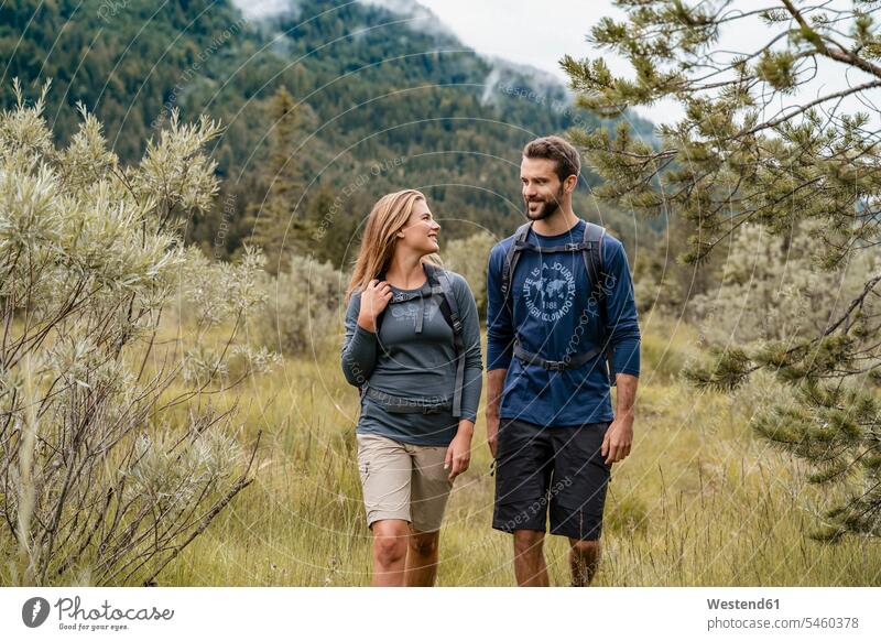 Young couple on a hiking trip, Vorderriss, Bavaria, Germany touristic tourists back-pack back-packs backpacks rucksack rucksacks go going walk smile speak