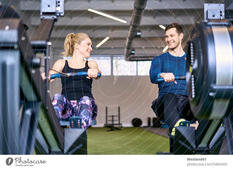 Man and woman at gym exercising together on rowing machines - a Royalty Free  Stock Photo from Photocase