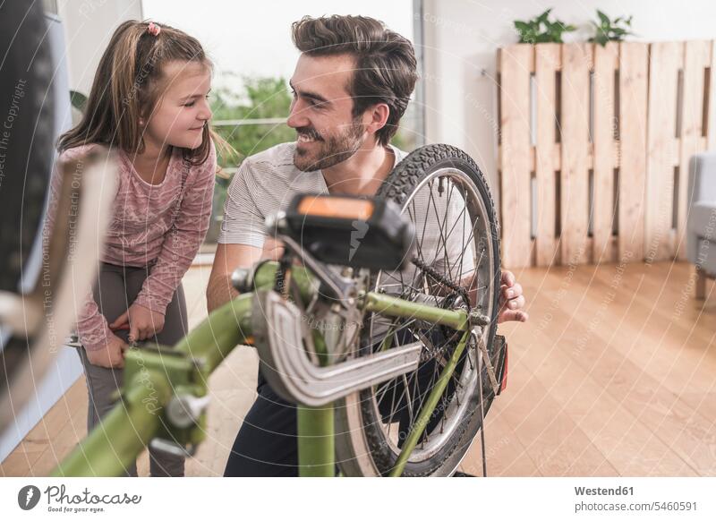 Young man and little girl repairing bicycle together Germany Quality Time Single Father Showing show one parent sustainability sustainable DIY do-it-yourself