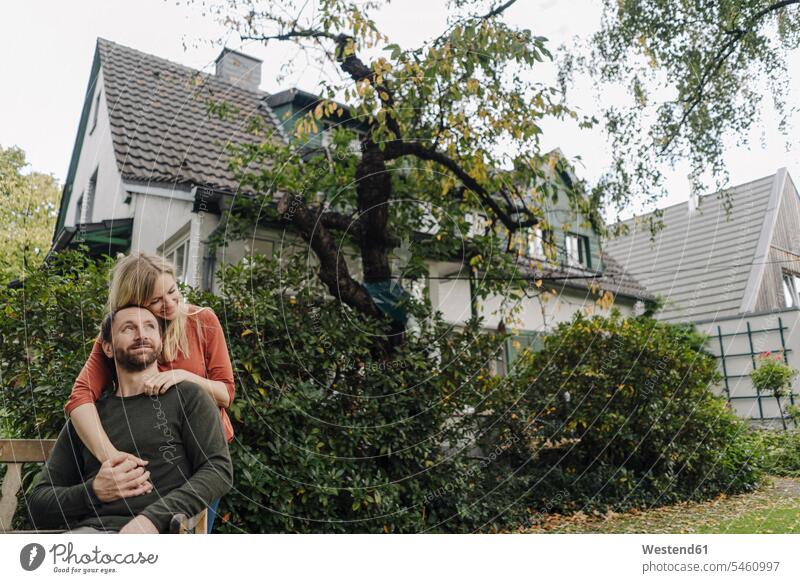 Affecionate couple embracing in their garden smile embrace Embracement hug hugging Secure happy Emotions Feeling Feelings Sentiment Sentiments loving