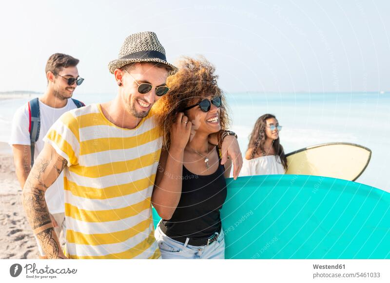 Group of friends walking on the beach, carrying surfboards Fun having fun funny together going beaches laughing Laughter friendship surfing surf ride