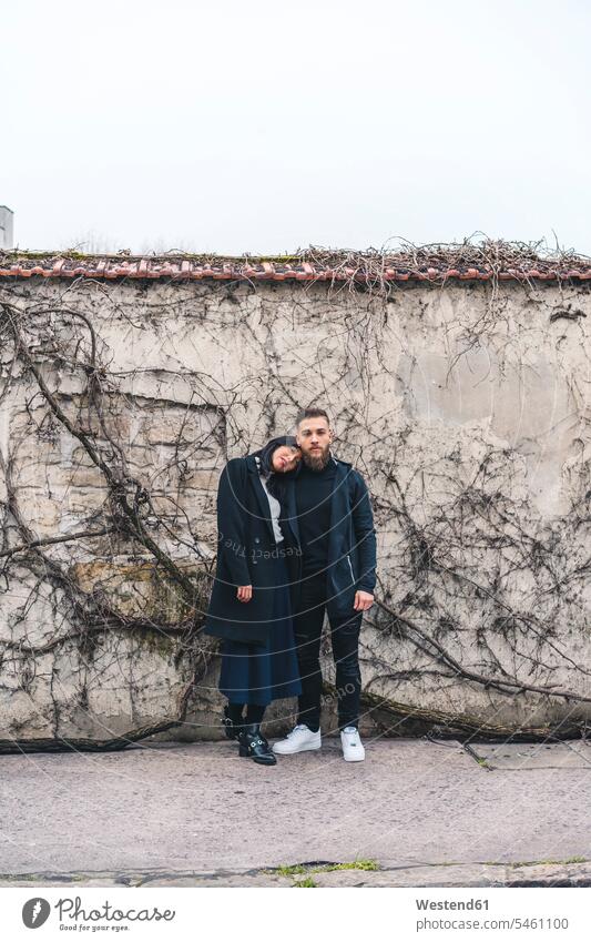 Young couple standing in front of wall twosomes partnership couples walls people persons human being humans human beings winter hibernal Head on Shoulder