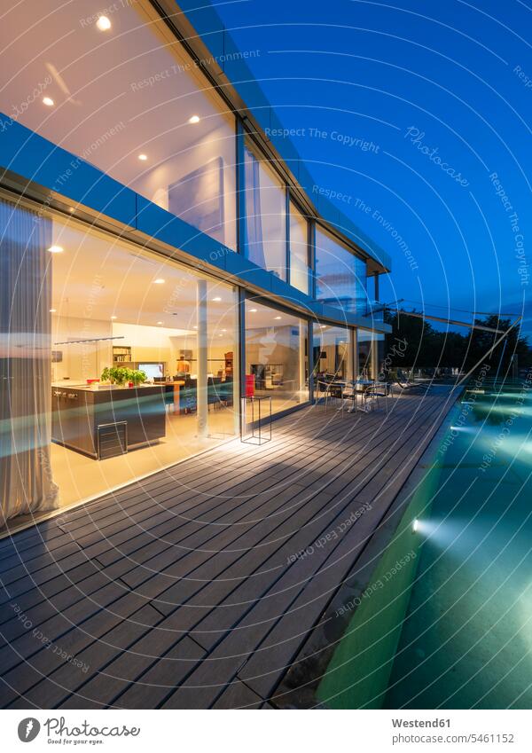Switzerland, lighted modern villa at dusk with terrace and pool in the foreground Facade Facades glass front glass facade Glass front illuminated lit