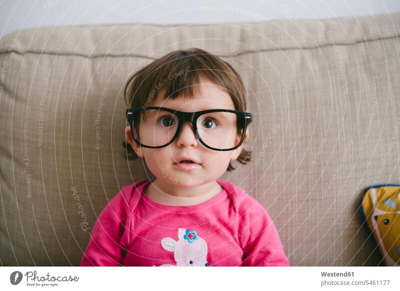 Portrait of staring baby girl wearing oversized glasses baby girls female gazing glare gaze glaring stare portrait portraits humongous gigantic giant enormous