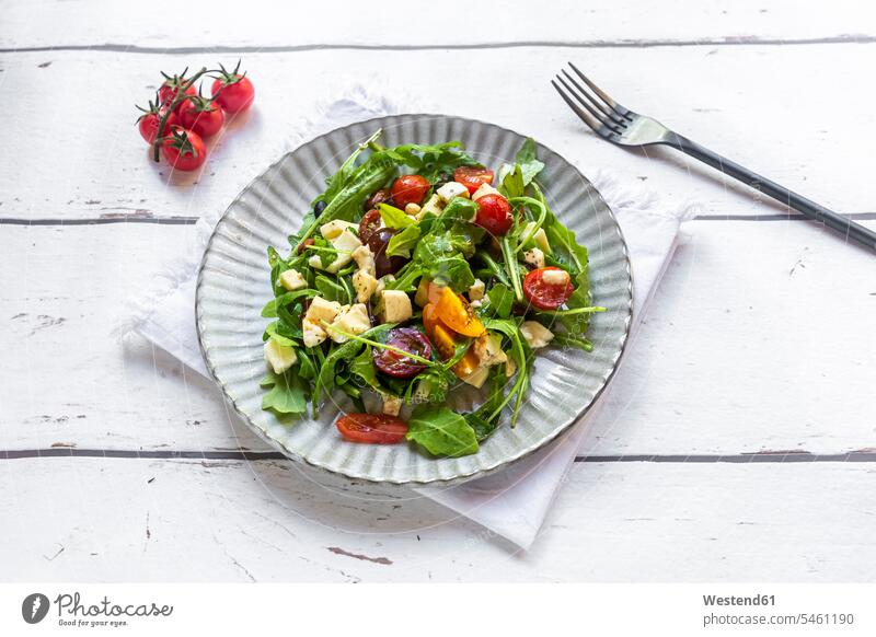 Plate of low carb vegetarian salad with arugula, tomatoes, nuts and Mozzarella cheese elevated view High Angle View High Angle Shot close-up close up closeup