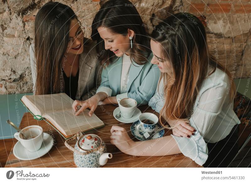 https://www.photocase.com/photos/5461330-three-young-women-reading-a-book-in-a-cafe-spain-photocase-stock-photo-large.jpeg