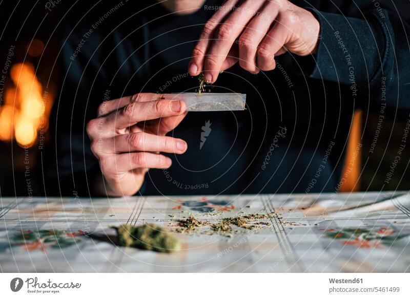 Close-up of a man's hands preparing marihuana joint tobacco Tobacco Products cigarettes hold smoke at home free time leisure time young culture indoor