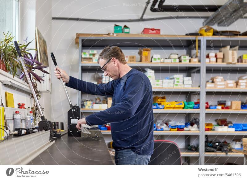 Man using punching machine in workshop human human being human beings humans person persons caucasian appearance caucasian ethnicity european 1 one person only