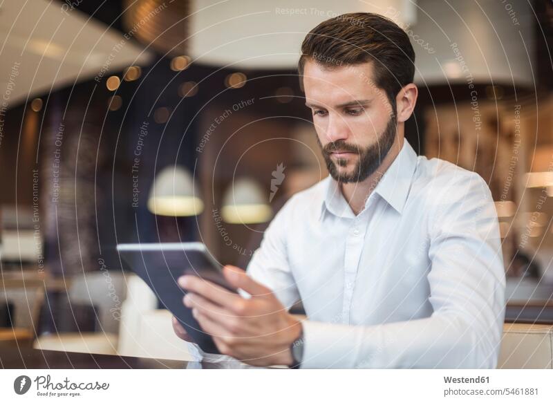 Young businessman using tablet in a cafe Businessman Business man Businessmen Business men digitizer Tablet Computer Tablet PC Tablet Computers iPad