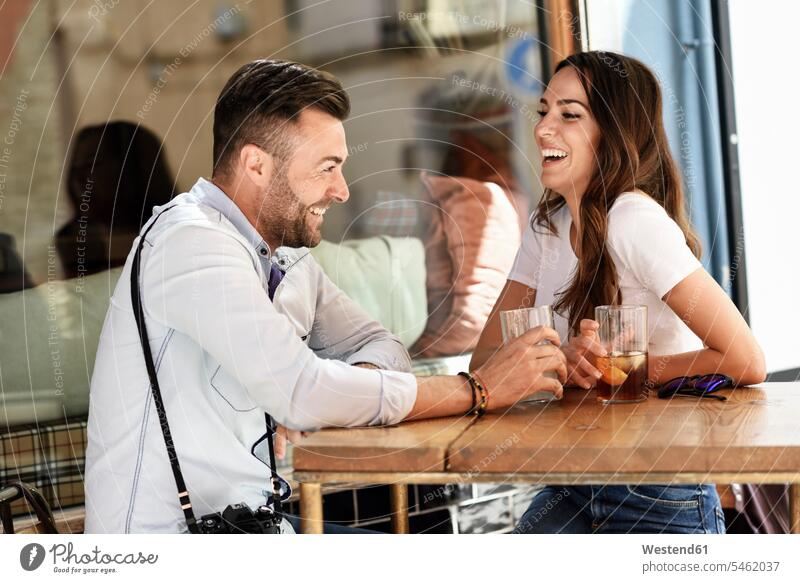 Happy couple having a drink at an outdoor bar in the city bars town cities towns twosomes partnership couples happiness happy Drink beverages Drinks Beverage