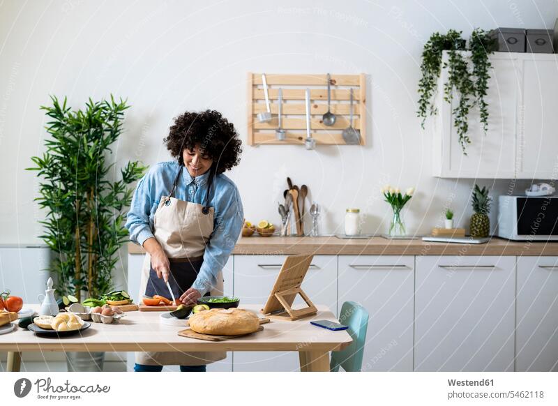 Young woman preparing vegan sandwiches in kitchen indoors indoor shot indoor shots interior interior view Interiors day daylight shot daylight shots day shots