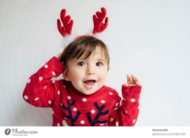 Portrait of baby girl with reindeer antlers headband at Christmas time christmas time yule-tide yuletide caribu caribou reindeers rangifer tarandus portrait