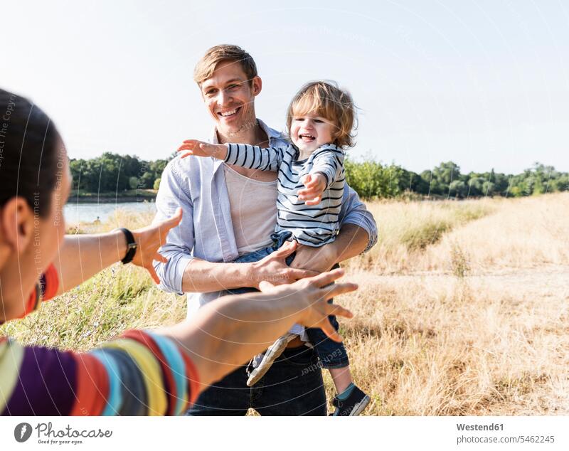 Happy family walking at the riverside on a beautiful summer day going Meadow Meadows happiness happy riverbank summer time summery summertime Plant Plants