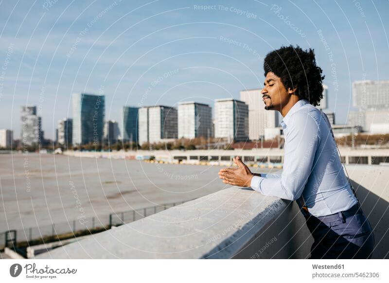 Spain, Barcelona, man leaning on balustrade enjoying sunlight indulgence enjoyment savoring indulging Sunlit rested on parapet males pleasure sunshine Sunny Day