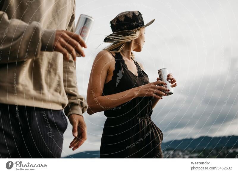 Young couple having a drink outdoors friends mate cans celebrate partying seasons summer time summertime summery relax relaxing relaxation stand free time