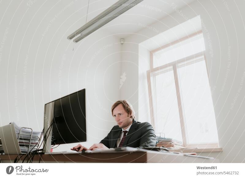 Businessman using computer at desk in office caucasian caucasian ethnicity caucasian appearance european day daylight shot daylight shots day shots daytime