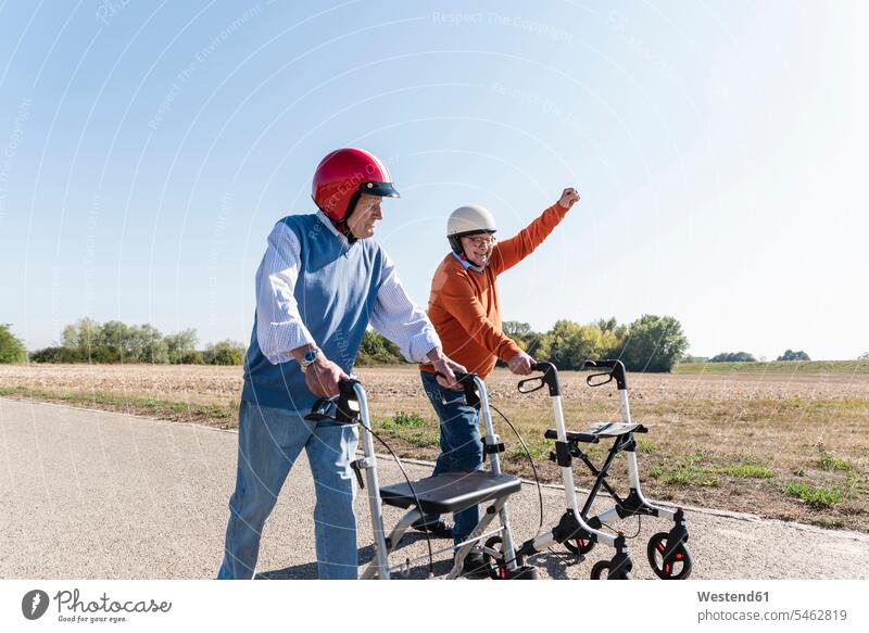 Two old friends wearing safety helmets, competing in a wheeled walker race Best Friend Best Friends Best Pal Safety Helmet protective helmet racing races