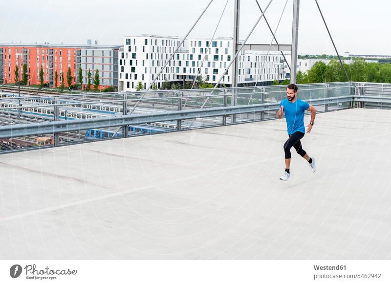 Man running on a parking level man men males Adults grown-ups grownups adult people persons human being humans human beings parking garage parking garages