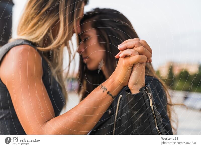 Affectionate lesbian couple holding hands outdoors human hand human hands twosomes partnership couples people persons human being humans human beings girlfriend