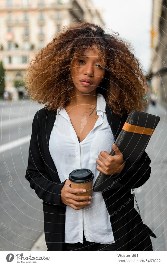 Young woman with laptop bag and coffee to go in the city, missing the taxi road streets roads female Hispanic females women laptop case looking view seeing