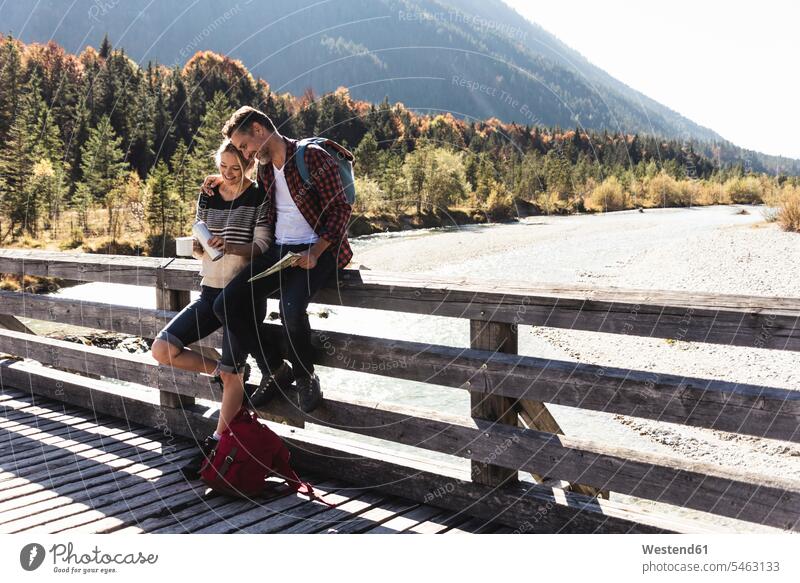 Austria, Alps, couple on a hiking trip having a break on a bridge caucasian caucasian appearance caucasian ethnicity european White - Caucasian mature men
