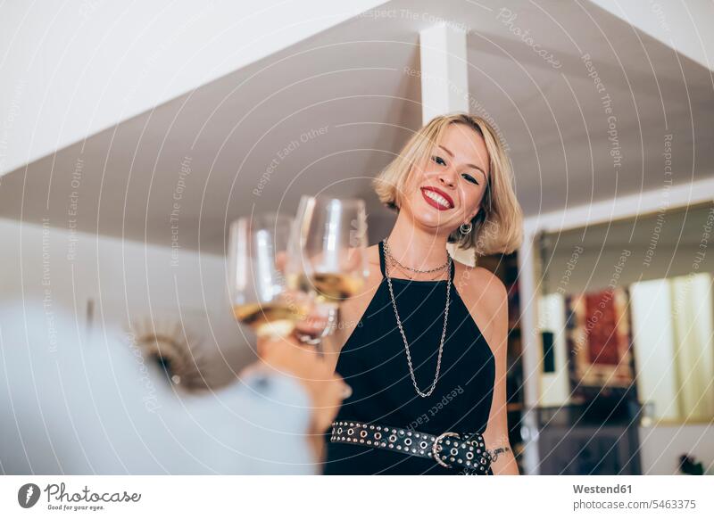 Smiling young woman toasting wineglasses during party at home color image colour image indoors indoor shot indoor shots interior interior view Interiors