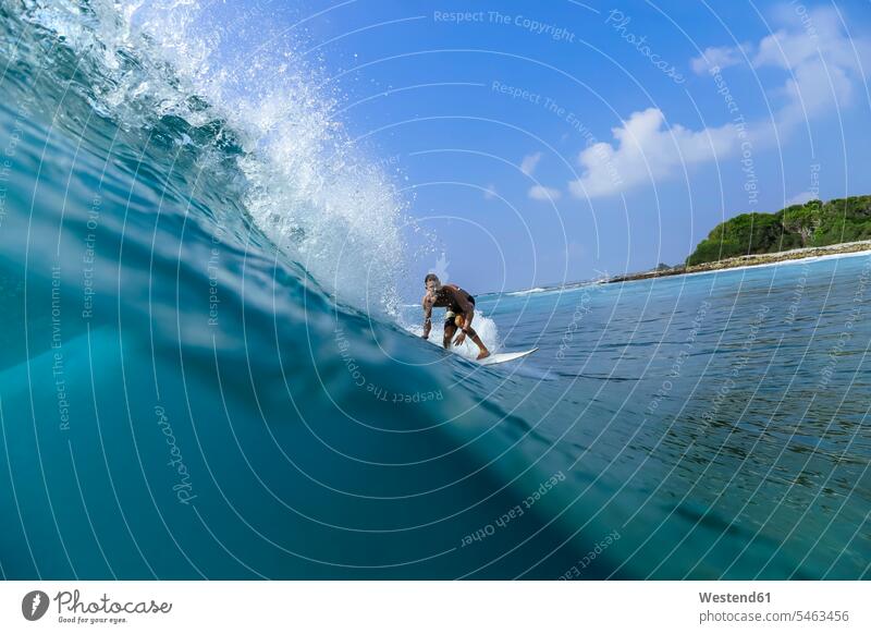Man surfing on wave with surfboard in sea against sky color image colour image outdoors location shots outdoor shot outdoor shots day daylight shot
