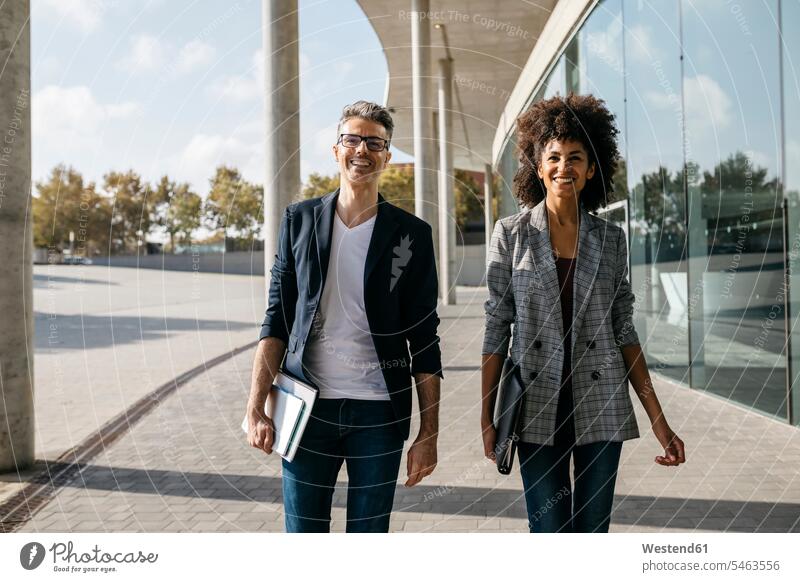 Portrait of two happy colleagues outside office building office buildings portrait portraits built structure built structures Spain three-quarter length