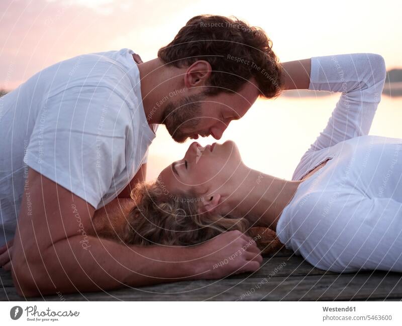 Romantic couple lying on jetty, kissing kisses seasons spring season Spring Time springtime happy Emotions Feeling Feelings Sentiment Sentiments loving