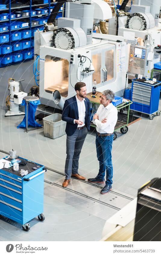 Businessmen during meeting in production hall man males discussion discussing factory factories Adults grown-ups grownups adult people persons human being