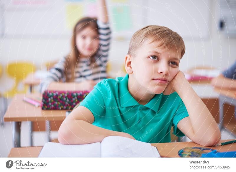 Bored schoolboy in class with girl raising her hand in background Boredom boring bored schools school class Schoolboy Schoolboys schoolgirl female pupils