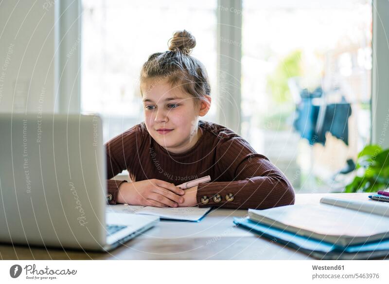 Girl with book using laptop while studying at home color image colour image indoors indoor shot indoor shots interior interior view Interiors day daylight shot