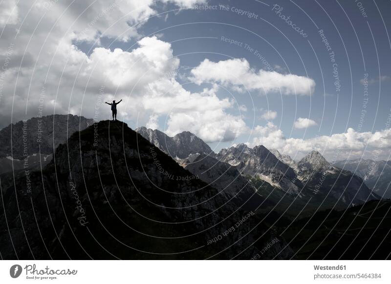 Austria, Tyrol, silhouette of man cheering on mountain peak - a Royalty  Free Stock Photo from Photocase