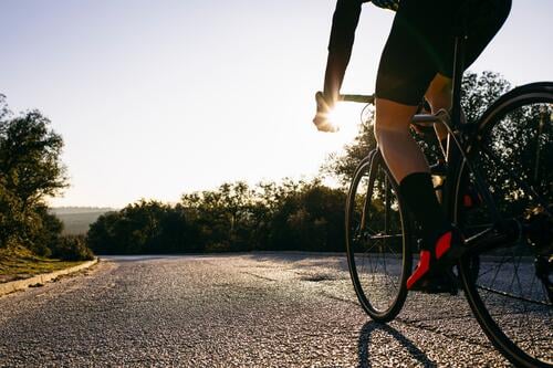 Close-up of athlete riding bicycle on country road at sunset bikes bicycles bike - bicycle Cycle Cycle - Vehicle racing bicycle racing bicycles racing bike