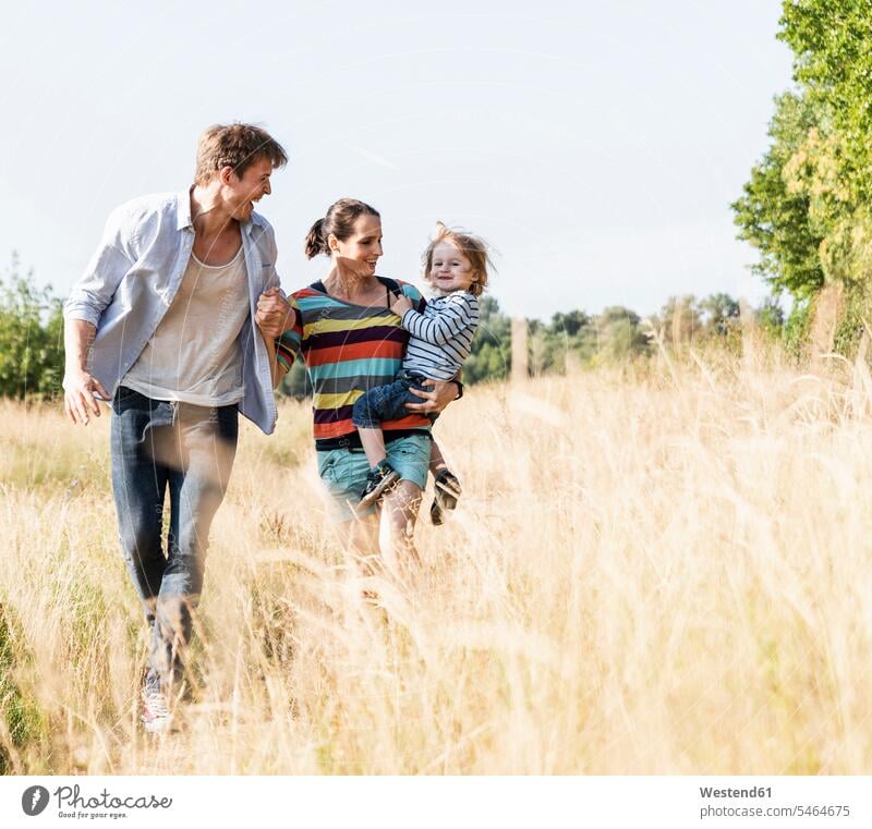 Happy family walking at the riverside on a beautiful summer day going happiness happy Meadow Meadows summer time summery summertime Plant Plants caucasian