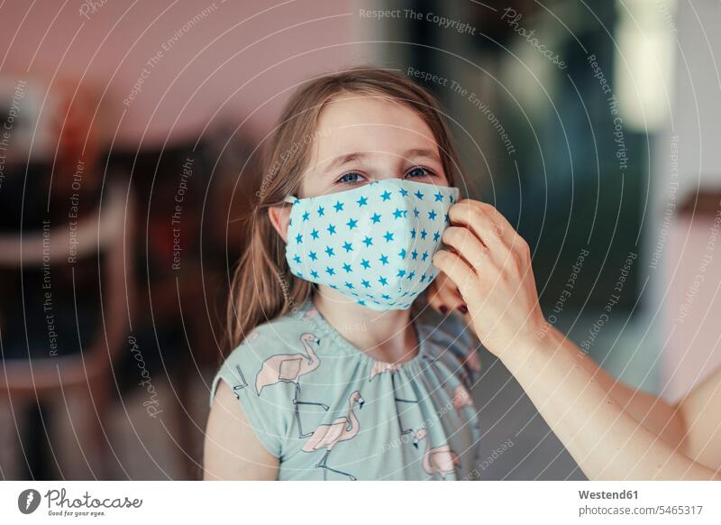 Mother tries mask on daughter's face at home color image colour image indoors indoor shot indoor shots interior interior view Interiors day daylight shot