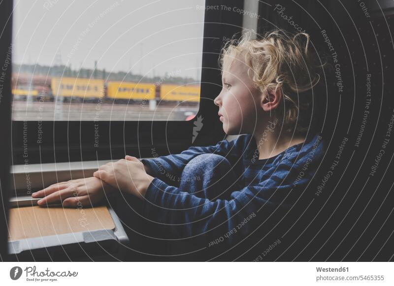 Little boy sitting in train looking out of window human human being human beings humans person persons caucasian appearance caucasian ethnicity european