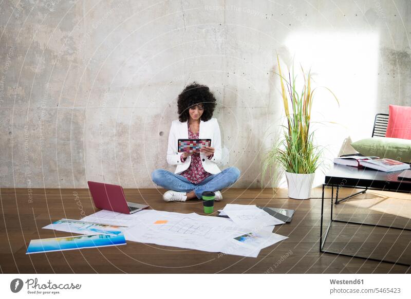 Businesswoman sitting on the floor in a loft using tablet floors digitizer Tablet Computer Tablet PC Tablet Computers iPad Digital Tablet digital tablets Seated