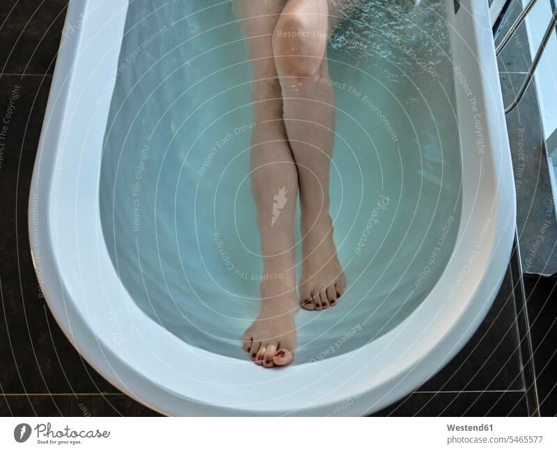 Senior woman taking bath in bathtub at luxury hotel room color image colour image indoors indoor shot indoor shots interior interior view Interiors day