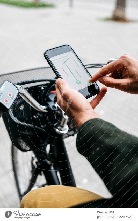 Close-up of man with e-bikeusing smartphone navigation system route guidance system bicycle bikes bicycles mobile phone mobiles mobile phones Cellphone