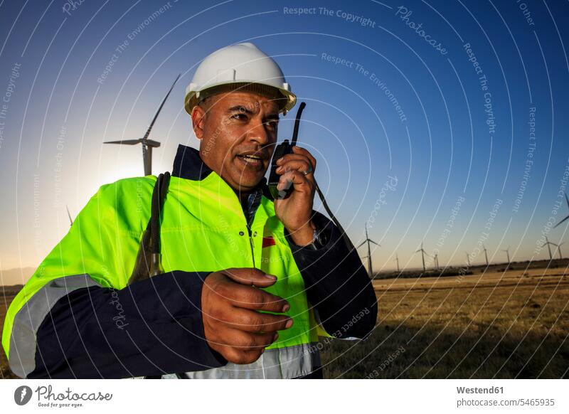 Technician using walkie-talkie on a wind farm walkie talkie walkie-talkies walkie talkies two-way radios wind park technician technicians wind power plant