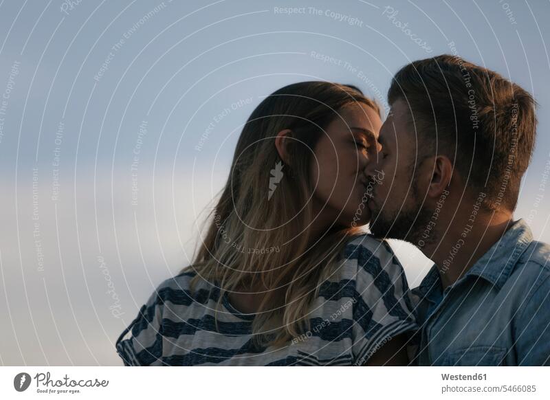 Young couple kissing outdoors kisses twosomes partnership couples people persons human being humans human beings Passion nature natural world togetherness