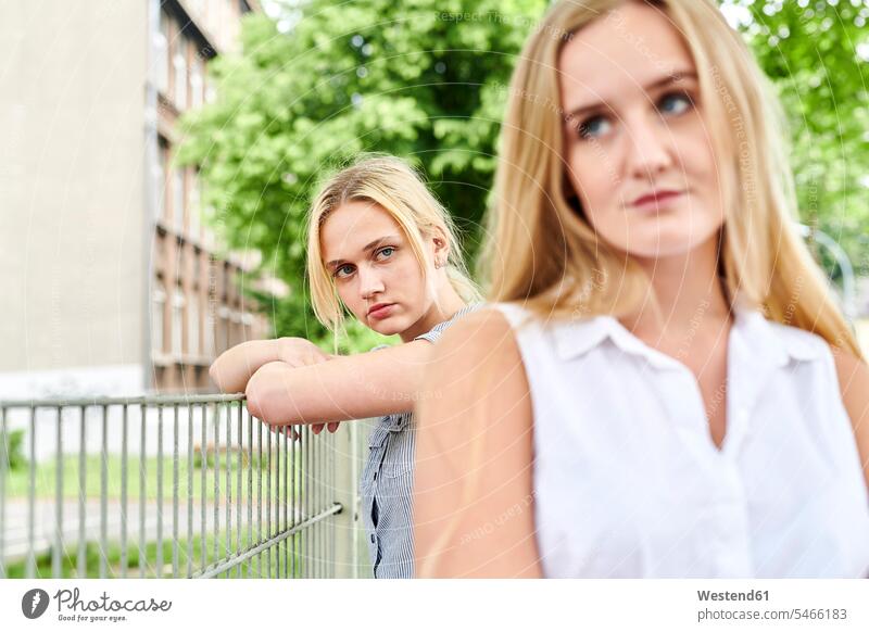 Two discontented young women outdoors female friends Discontent unsatisfied dissatisfaction city town cities towns woman females mate friendship outdoor shots