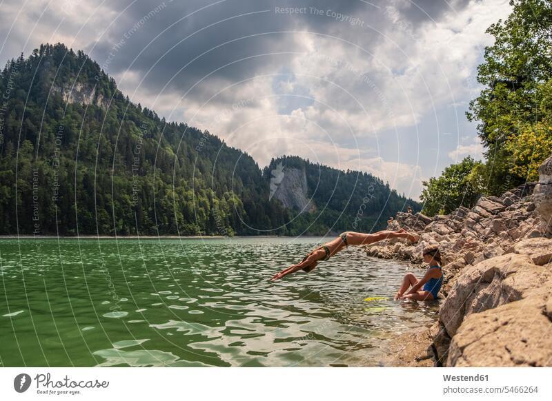 Austria, Salzkammergut, Mondsee, woman with daughter jumping into lake lakes Leaping water waters body of water jumps Refreshment refreshing bikini bikinis