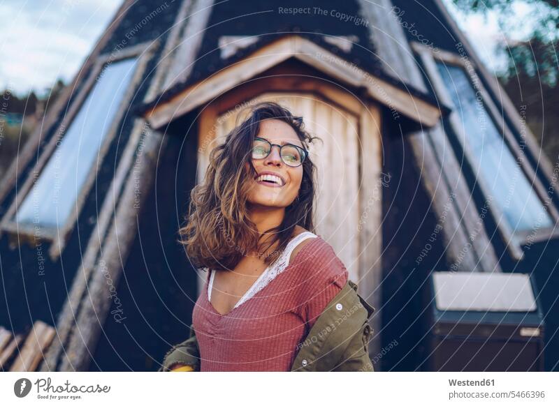 Portrait of a laughing young woman infront of a Finnish house Finland frame house wooden houses framehouses Laughter portrait portraits young women Scandinavia