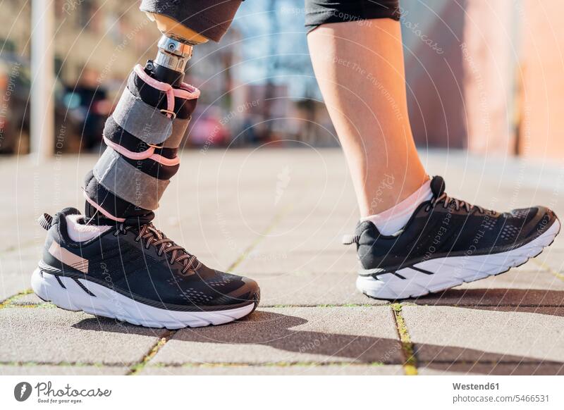 Close-up of legs of sporty woman with leg prosthesis in the city exercise practising train training go going walk sports fit free time leisure time